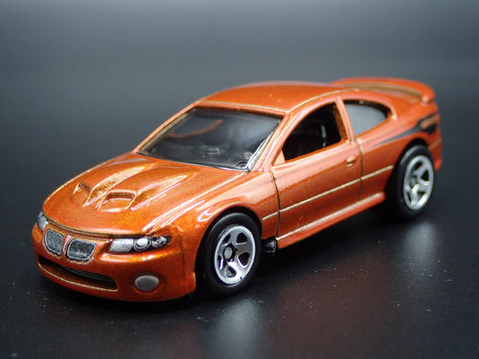 2004-2006 PONTIAC GTO ORANGE 1:64 SCALE COLLECTIBLE DIORAMA DIECAST MODEL CAR