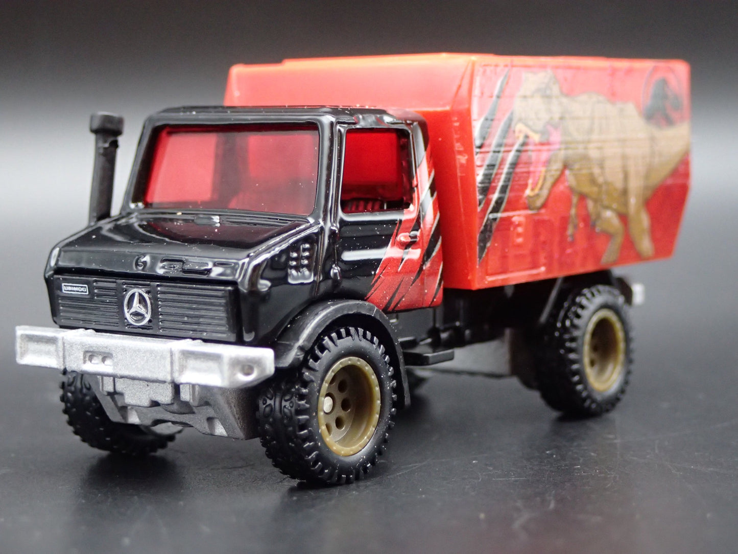MERCEDES-BENZ UNIMOG U 1300L JURASSIC WORLD 1:64 SCALE DIORAMA DIECAST MODEL CAR