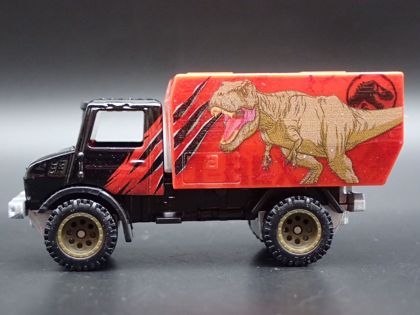 MERCEDES-BENZ UNIMOG U 1300L JURASSIC WORLD 1:64 SCALE DIORAMA DIECAST MODEL CAR