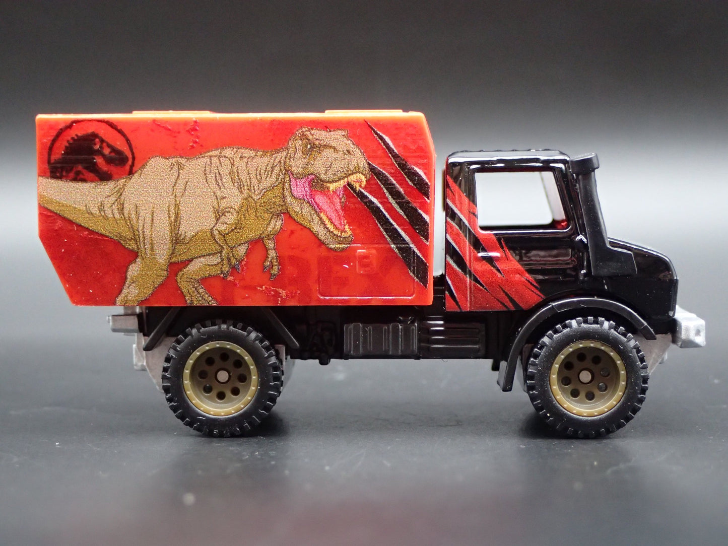 MERCEDES-BENZ UNIMOG U 1300L JURASSIC WORLD 1:64 SCALE DIORAMA DIECAST MODEL CAR