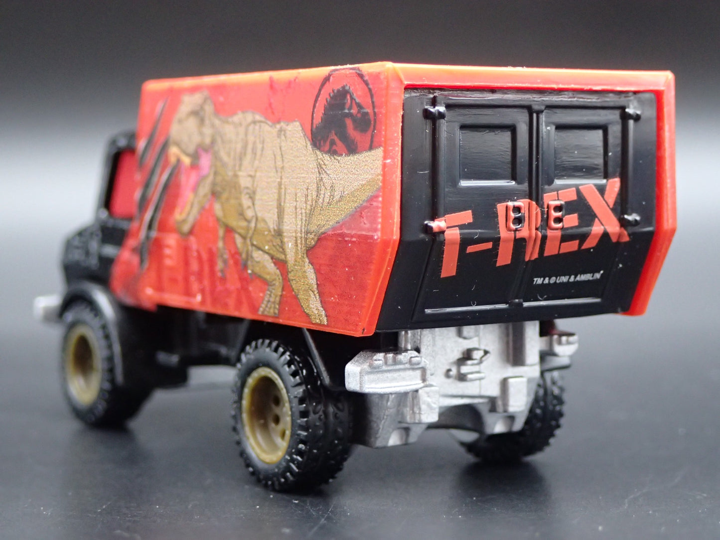 MERCEDES-BENZ UNIMOG U 1300L JURASSIC WORLD 1:64 SCALE DIORAMA DIECAST MODEL CAR