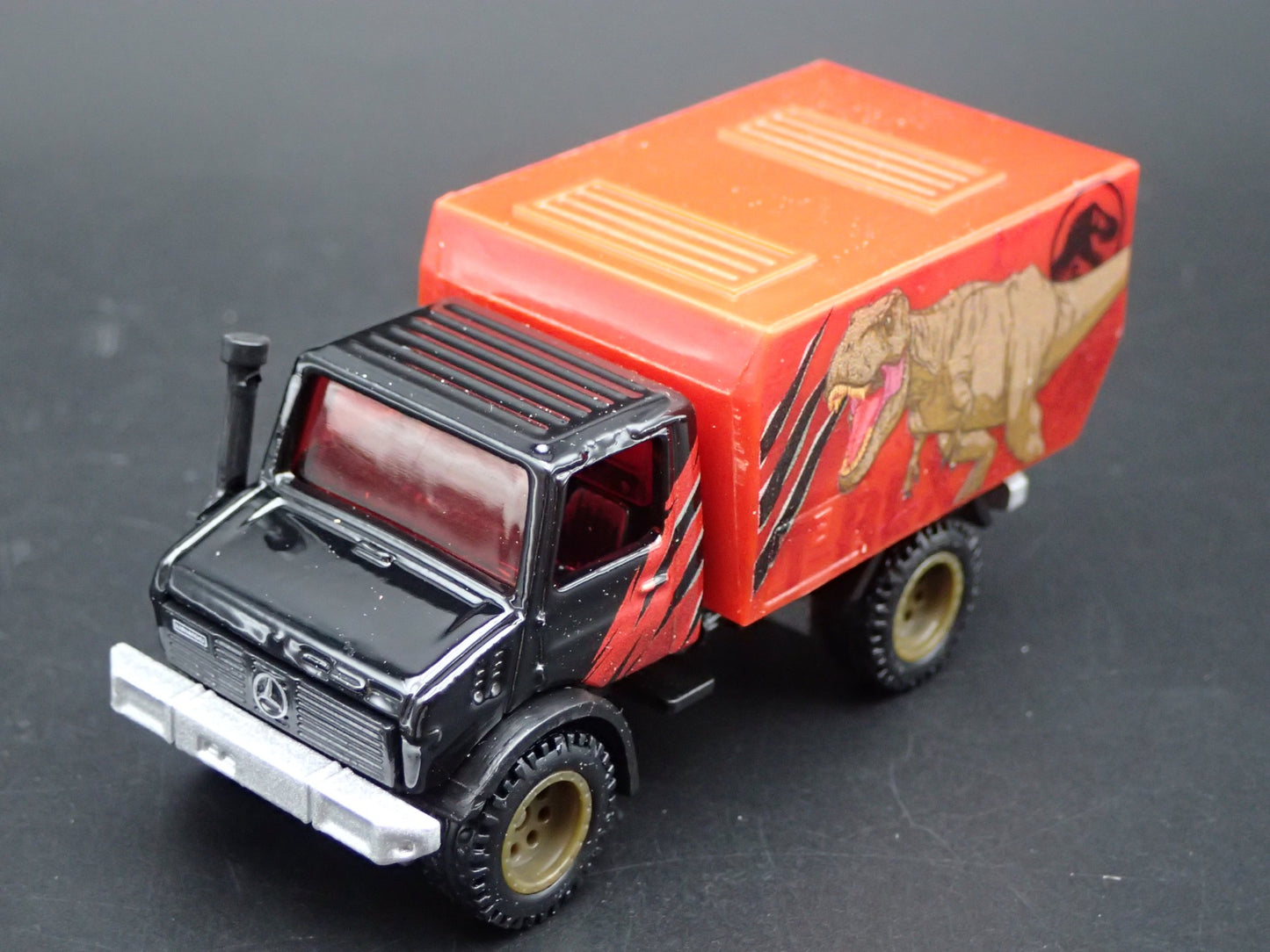 MERCEDES-BENZ UNIMOG U 1300L JURASSIC WORLD 1:64 SCALE DIORAMA DIECAST MODEL CAR