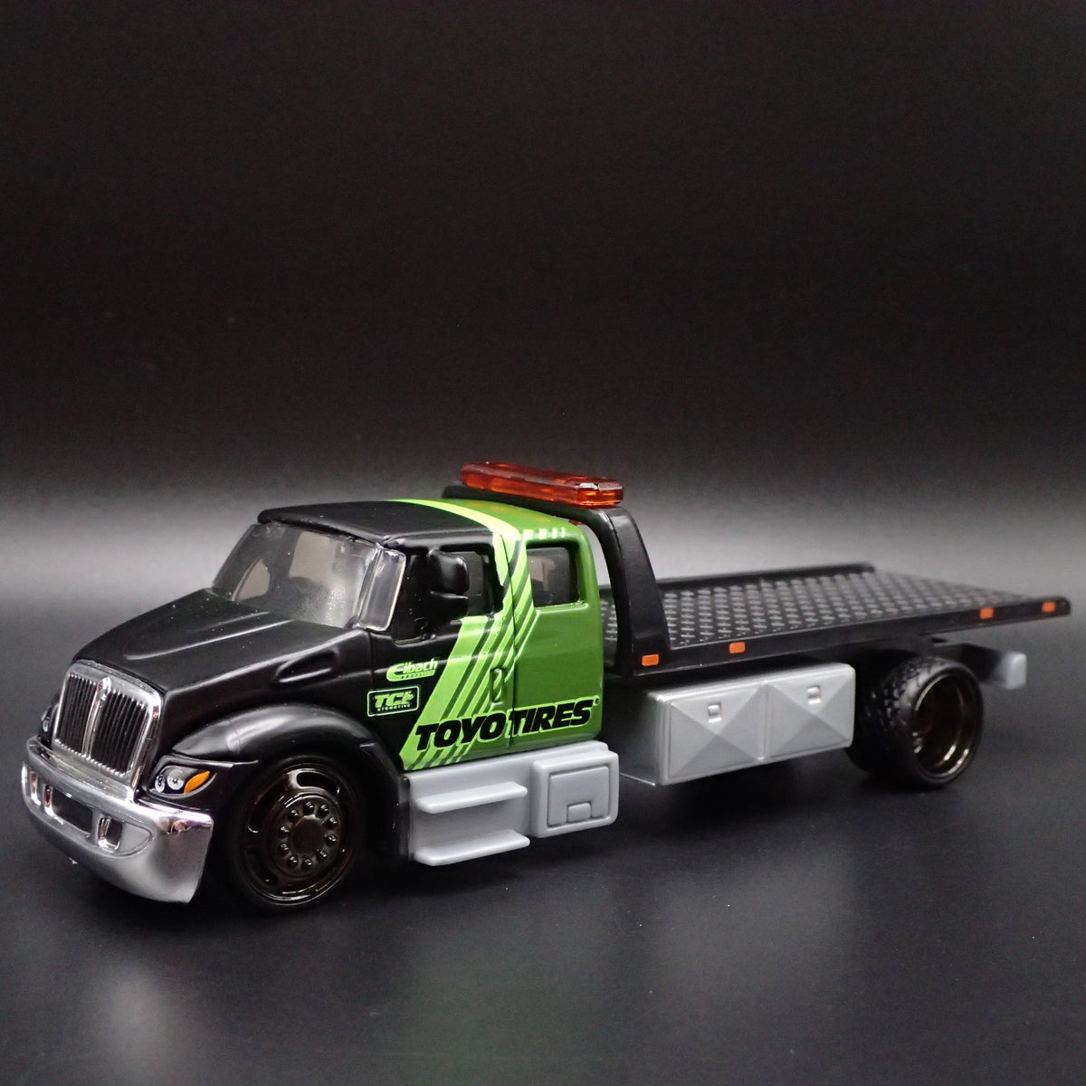 INTERNATIONAL DURASTAR FLATBED TOW TRUCK TOYO TIRES 1/64 SCALE DIECAST MODEL CAR-Burning Rubber Toy Company