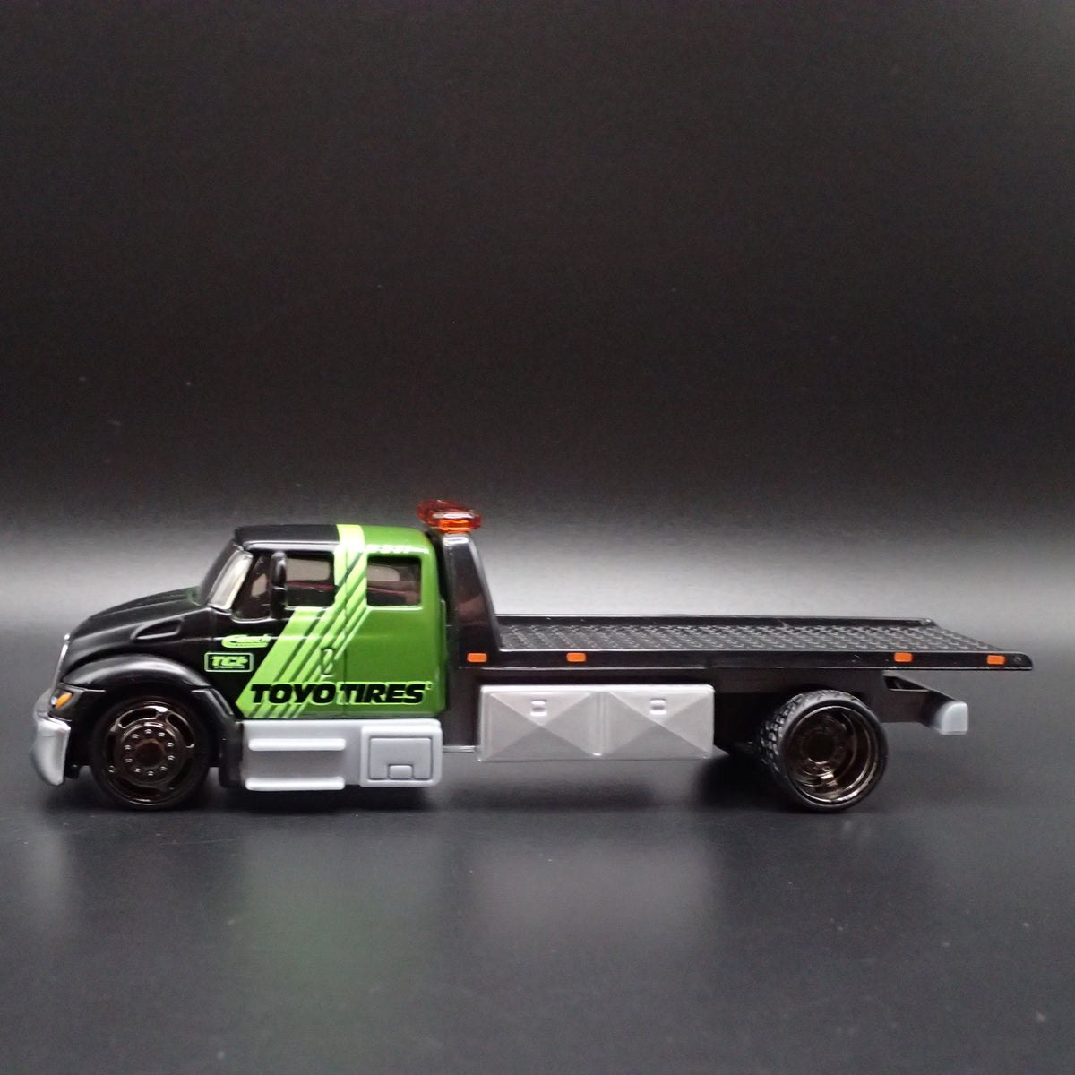 INTERNATIONAL DURASTAR FLATBED TOW TRUCK TOYO TIRES 1/64 SCALE DIECAST MODEL CAR-Burning Rubber Toy Company