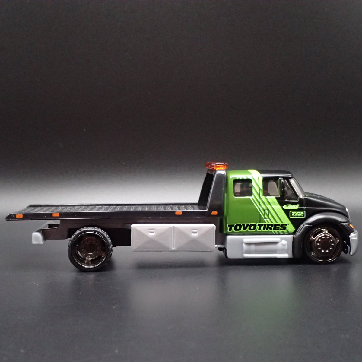 INTERNATIONAL DURASTAR FLATBED TOW TRUCK TOYO TIRES 1/64 SCALE DIECAST MODEL CAR-Burning Rubber Toy Company